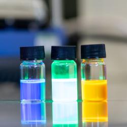 Three coloured vials on a lab work bench.