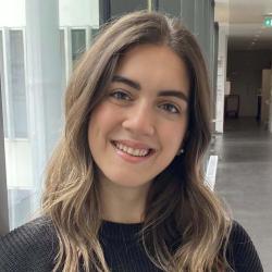 Dina smiling at the camera in a headshot.