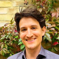 Profile image of white man with dark hair, in blue shirt