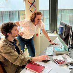 Professor Ljiljana Fruk stood at a desk looking at a computer screen with a man sat at the desk holding a computer mouse.